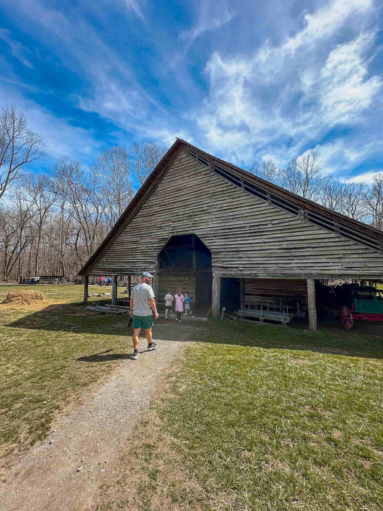 family walking towards old barn at the farm museum in smoky mountain national park