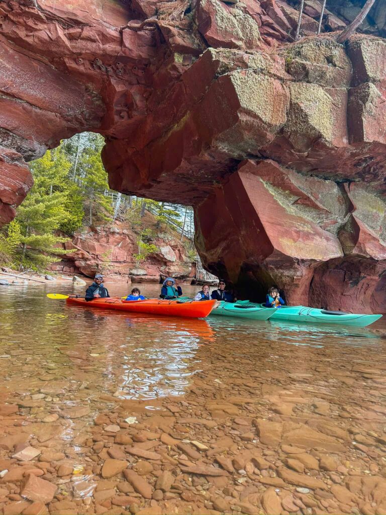 family kayaking in the sea caves at apostle islands national lakeshore
