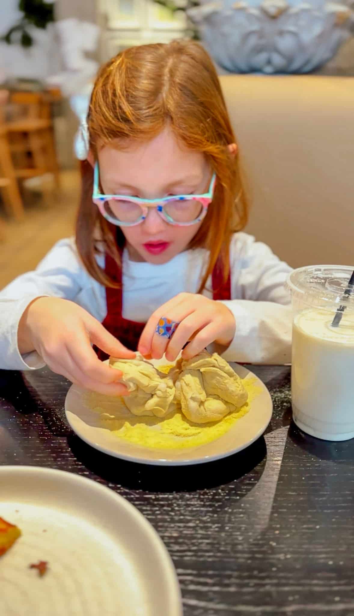 Child making pasta at restaurant.