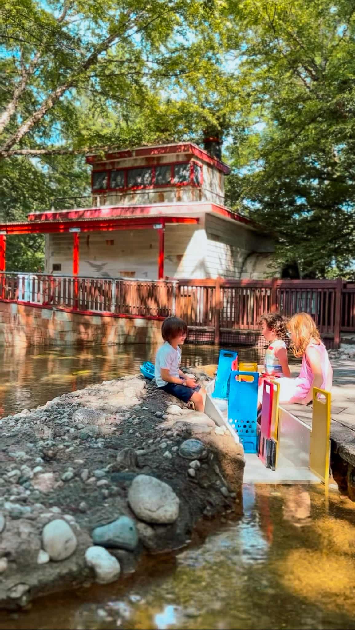 Children playing by a serene pond.