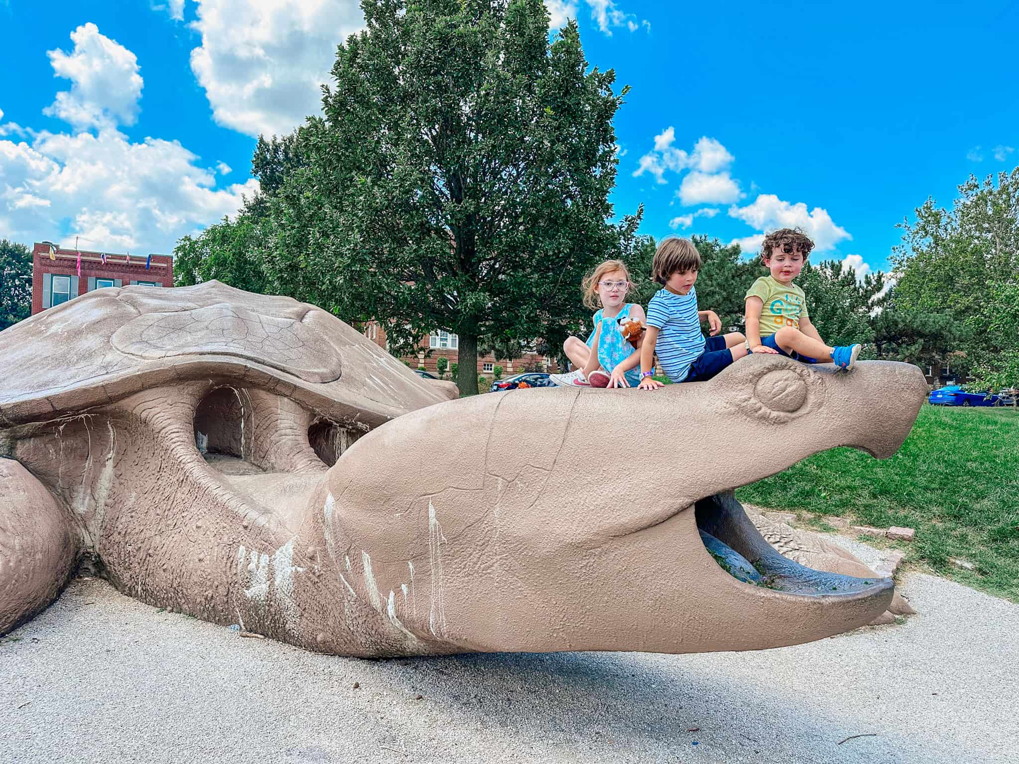 Children sitting on turtle sculpture