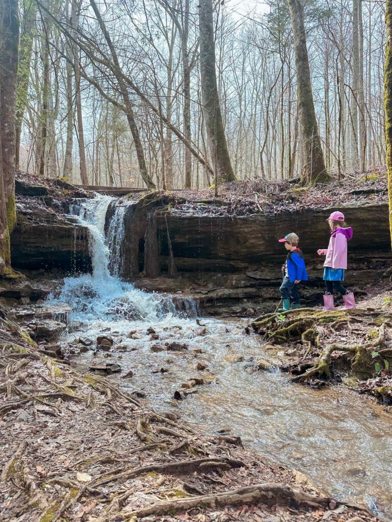 Children playing in a waterfall along the trail at Burgess falls state park in Tennessee