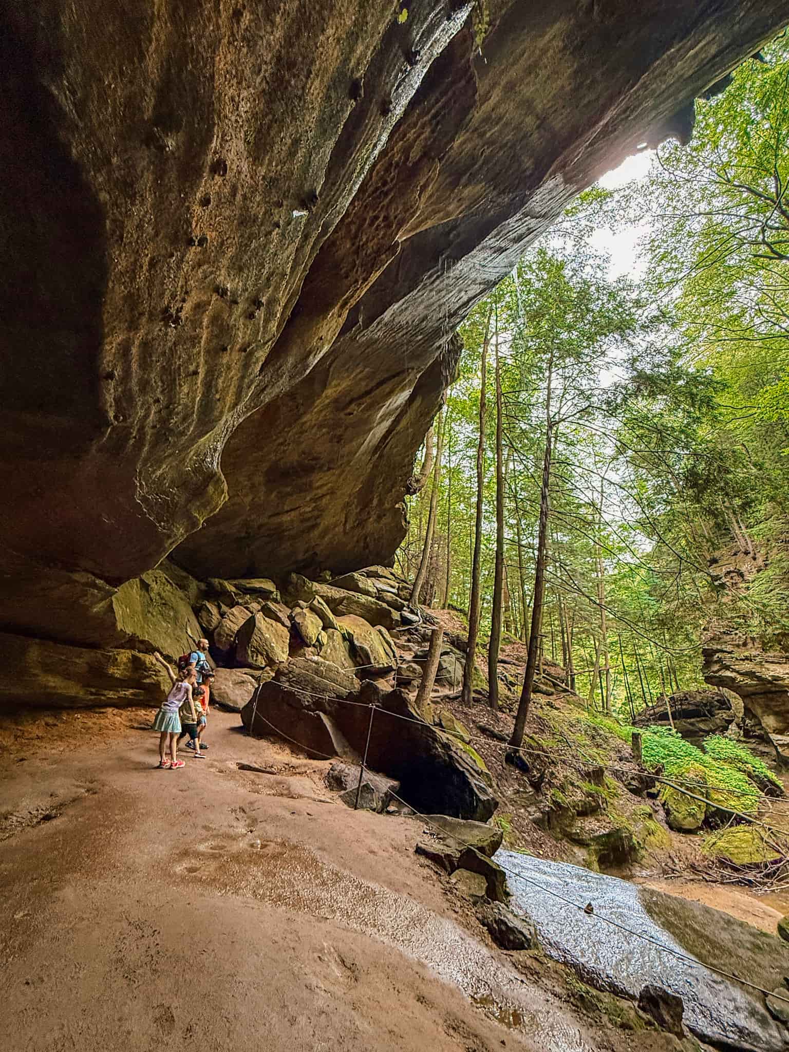 family standing in old mans cave in hocking hills ohio