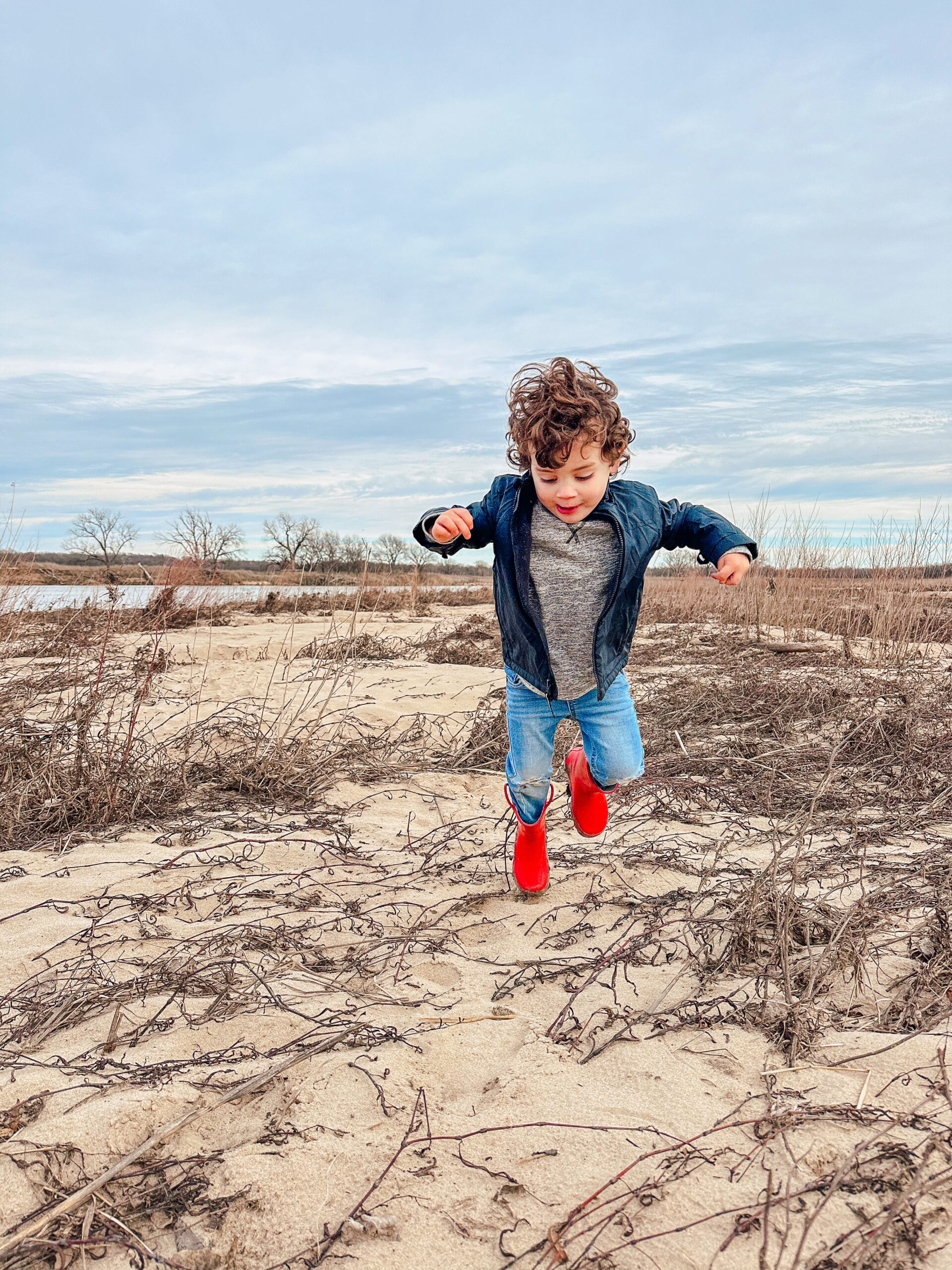 child jumping on banks of Arkansas River 