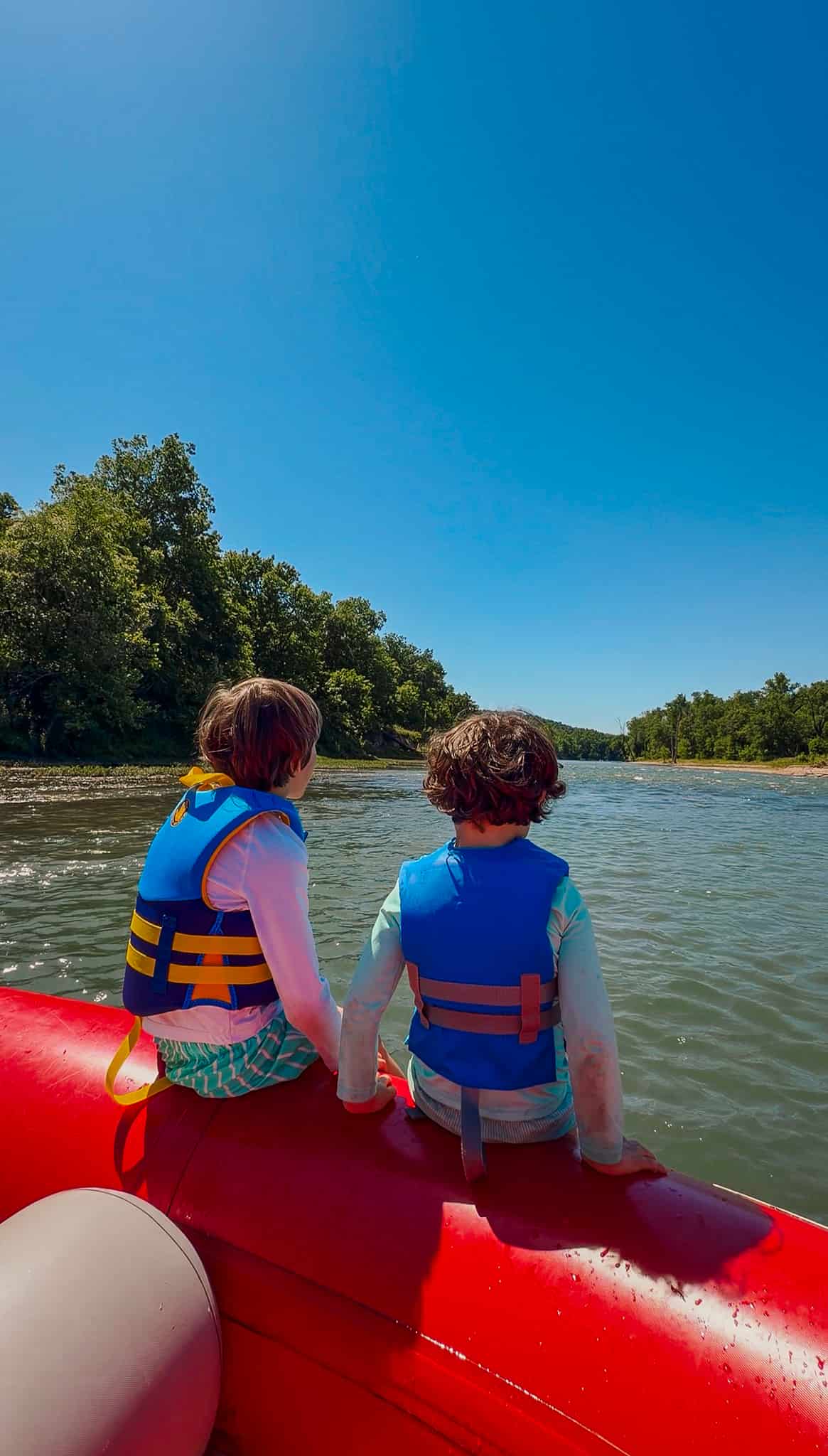 boys sitting on raft on illinois river 